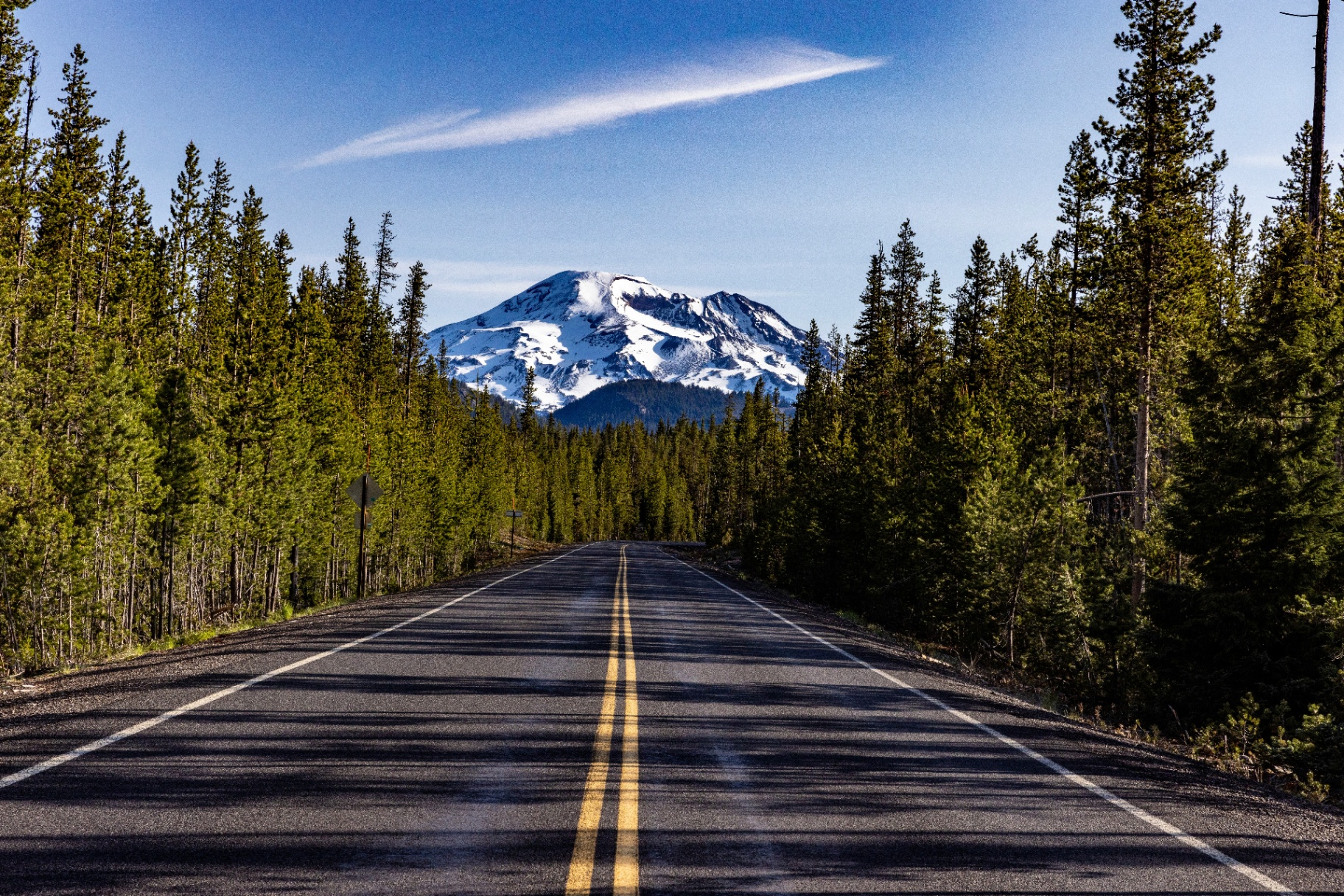 Scenic road leading toward a snow-capped Cascade mountain near Bend, Oregon